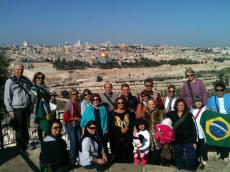 Grupo Magnificat emoldurado pela vista de Jerusalém desde o Monte das Oliveiras
